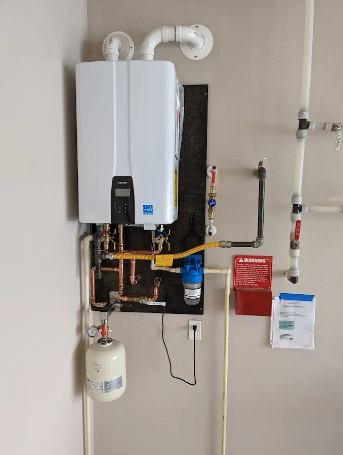 Professional plumber installing copper piping in a Providence home